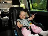 Imagen de un bebé en una silla adaptada en el interior de un vehículo.