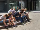 Adolescentes consultando sus teléfonos móviles.