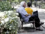 Un pensionista descansa en un banco de un parque
