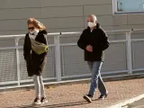 Dos ciudadanos con mascarillas llegan al Hospital de Torrej&oacute;n de Ardoz.