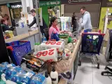 Una cajera pasa los productos de un cliente tras vaciar su carro, en otro supermercado de Madrid.