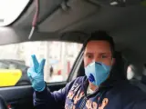 Fernando Fillat dentro de su taxi, en Barcelona, equipado para no contagiarse del virus.