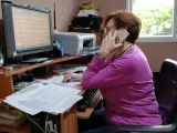 Una persona habla con mayores a través del teléfono puesto a disposición por la Diputación de Málaga