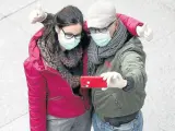 Una pareja se hace un selfi con mascarillas en Madrid.