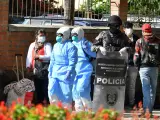 Polic&iacute;as y funcionarios de salud realizan aplican de prevenci&oacute;n por el coronavirus COVID-19 a bolivianos procedentes de los pa&iacute;ses vecinos, en la Villa Suramericana en Cochabamba (Bolivia).
