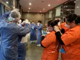 Sanitarios y trabajadores del hospital de campa&ntilde;a de Ifema se colocan las mascarillas antes de empezar a atender pacientes con coronavirus.