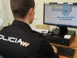 Agente de la Polic&iacute;a Nacional frente a un ordenador