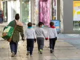 Una madre y sus hijos, con mascarillas, tras hacer la compra en Zaragoza, en una imagen de archivo.