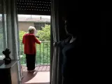 Juana se asoma al balcón de su casa mientras su hija le observa.