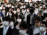 Pasajeros con mascarillas por la pandemia del coronavirus, en la estación de Shinagawa, en Tokio, Japón, durante la hora punta.