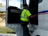 Agente de la Guardia Civil inspecciona el tacógrafo de un camión, que habría sido manipulado.