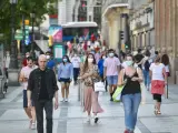 Personas paseando con mascarilla por Madrid.
