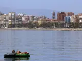 MLG 20-05-2020.-Una mujer toma el sol sobre un kayac en la playa de La Caleta durante la Fase 1 en Málaga.-ÁLEX ZEA.
