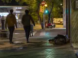 Una persona sin hogar durmiendo en la calle, cerca de la Estación de Sants de Barcelona, durante la noche del recuento de personas sin techo organizada por la Fundació Arrels el pasado 14 de mayo del 2020, durante la epidemia del coronavirus.