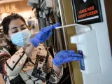 Una empleada se desinfecta con guantes en Alemania.
