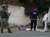 Integrantes de la Guardia Nacional, la Policía Estatal y los Servicios Periciales revisan el cuerpo de un hombre asesinado en una calle de Apaseo El Alto, en el estado de Guanajuato (México).