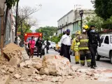 Miembros de la polic&iacute;a y de los bomberos observan los da&ntilde;os causados en una barda derrumbada, en la ciudad de Oaxaca (M&eacute;xico), tras un fuerte terremoto.