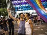 Una pareja de gais se da un beso, bajo una bandera arcoíris, durante una manifestación por el 'Orgullo 2020', en Tel Aviv (Israel).