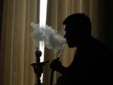 Una persona fumando cachimba.