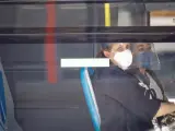 Dos mujeres con mascarilla y pantalla se sientan al lado en un autob&uacute;s de la EMT en Madrid.