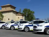 Varios coches policiales aparcados.