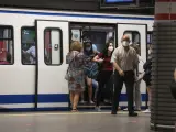 Pasajeros con mascarilla salen de un vagón en la estación de Metro de Atocha, en Madrid.