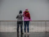 Dos mujeres en el paseo marítimo de Barcelona en un día de lluvia.