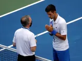 El tenista serbio Novak Djokovic habla con el &aacute;rbitro del Abierto de EE UU, Soeren Friemel, tras dar un pelotazo accidental a una juez de l&iacute;nea.