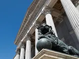 Uno de los emblemáticos leones que se encuentran delante de la fachada del Congreso de los Diputados en la Plaza de las Cortes de Madrid.