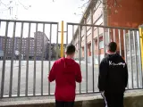 Dos adolescentes observan el patio de un colegio durante el confinamiento por el estado de alarma, en Vitoria / País Vasco (España), a 16 de abril de 2020.