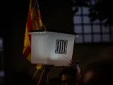 Un participante en la manifestaci&oacute;n de la ANC por el segundo aniversario del 1O con un cartel lleva una urna del refer&eacute;ndum y una estelada, en Barcelona a 1 de octubre de 2019.