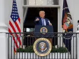 El presidente de EE UU, Donald Trump, saluda a sus simpatizantes desde un balcón de la Casa Blanca mientras se quita la mascarilla.