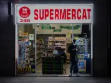 Un hombre con mascarilla en la puerta de un supermercado 24 horas de Barcelona. David Zorrakino / Europa Press