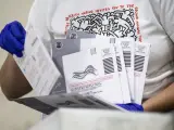 Una trabajadora verifica los datos y las direcciones en las papeletas enviadas por correo, en un centro electoral de Pomona, California (EE UU).