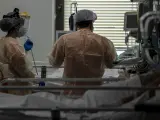Dos sanitarios atienden a un paciente en la UCI dedicada a enfermos de coronavirus del Hospital Ram&oacute;n y Cajal, en Madrid.