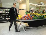 Persona ciega con perro guía en supermercado