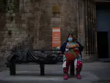 Una persona sin techo come en zonas exteriores de las instalaciones del hospital de campaña perteneciente a la parroquia de Santa Anna, en Barcelona.
