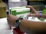 Una farmacéutica coloca una de las cajas de un test de antígeno para Covid-19, en Madrid (España)
