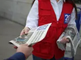Un repartidor de '20 minutos' entrega un ejemplar a un lector.