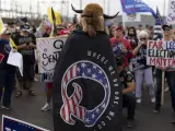 Un hombre lleva una capa en Phoenix (USA) con el símbolo de QAnon, una de las principales teorías de la conspiración de la extrema derecha estadounidense​​​​​ sobre una supuesta trama secreta organizada por un 'Estado profundo' contra Donald Trump y sus seguidores.