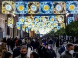 Varias personas disfrutan del encendido navide&ntilde;o en el centro de Sevilla.