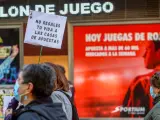 Una persona sostiene una pancarta donde se lee que 'No regales tu vida a las casas de apuestas' en una manifestación contra la proliferación de los locales de apuestas que ha tenido lugar en el barrio madrileño de Carabanchel.