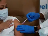 Una trabajadora sanitaria recibe la vacuna contra la COVID-19 de Moderna en un hospital de Nueva York, EE UU.