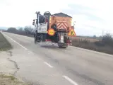 Un camión esparce sal en una carretera.
