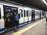 Gente entrando a un vag&oacute;n parado en el and&eacute;n de la estaci&oacute;n de metro de Atocha Renfe