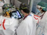 Sanitarios miran la radiografía de los pulmones de un paciente en la UCI del Hospital del Mar.