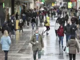 Gente pasea por la calle con mascarillas en Madrid.