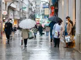 Varias personas pasean en una calle comercial en una jornada marcada por el inicio de la entrada en vigor de una desescalada gradual en la región, en Vigo, Galicia (España), a 17 de febrero de 2021. Galicia reabre hoy