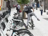 Archivo - Un hombre coge una bicicleta de bicimad aparcada en una calle de la capital