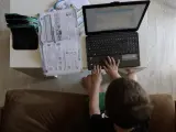 Archivo - Un niño utiliza el ordenador para hacer sus deberes.